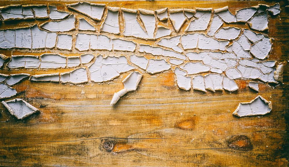 Image of old paint cracking and peeling off of a wooden surface